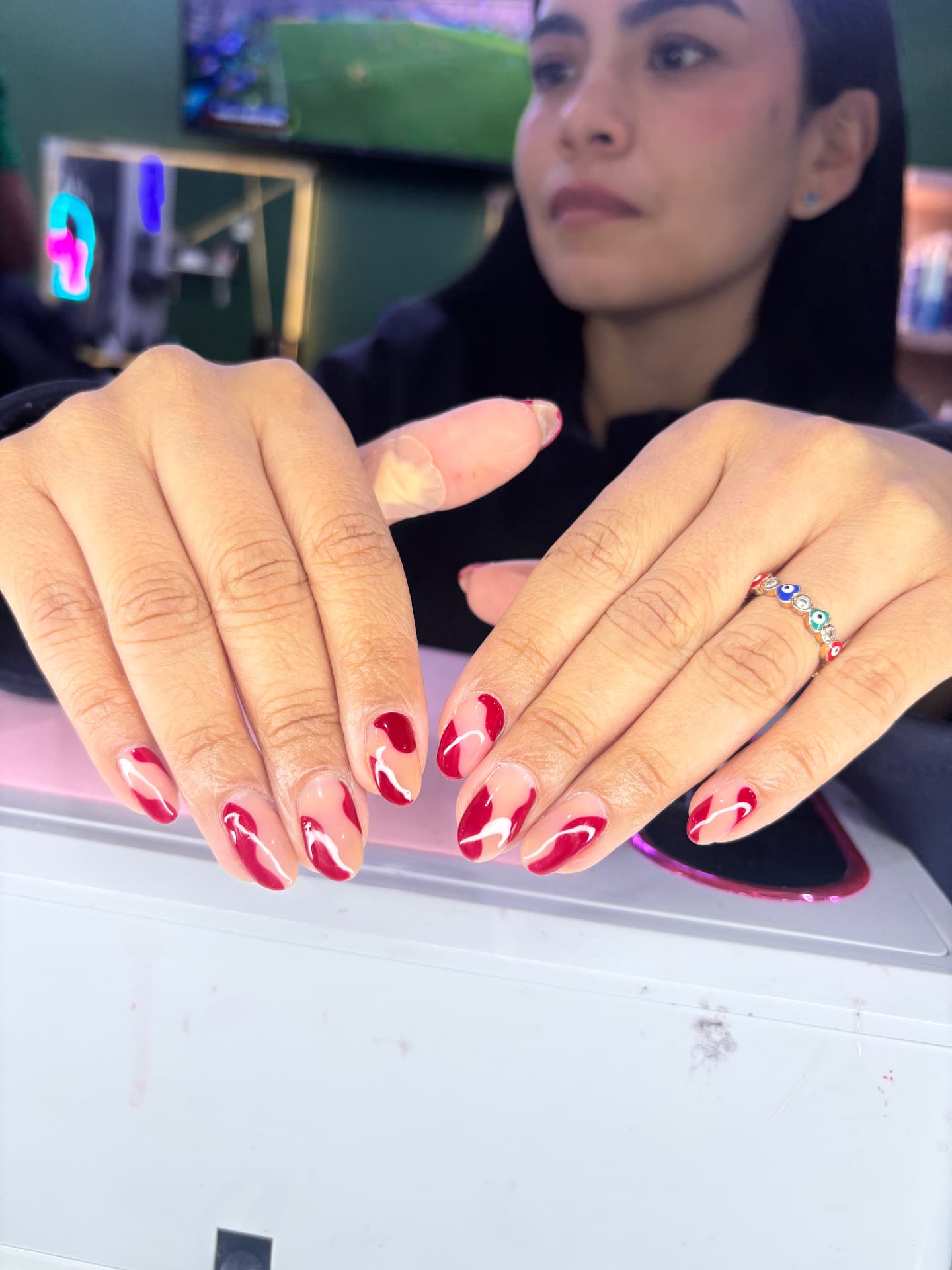 Uñas almendra rojas con línea blanca ondulada
